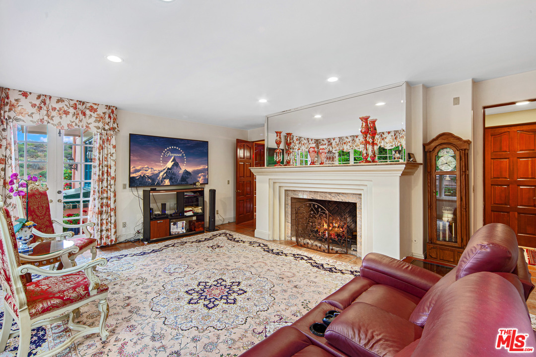 2113 Stoney Hill Road Los Angeles, CA 90049 - Photo 46 of 48 a living room with furniture a fireplace and a flat screen tv