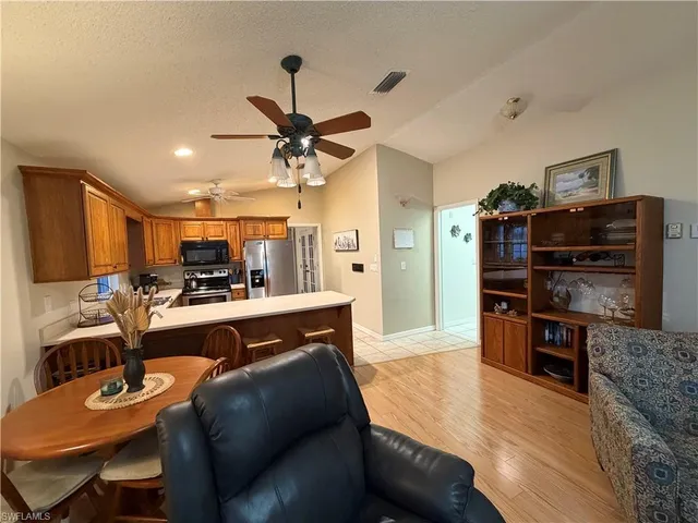 a living room with furniture a flat screen tv and kitchen view