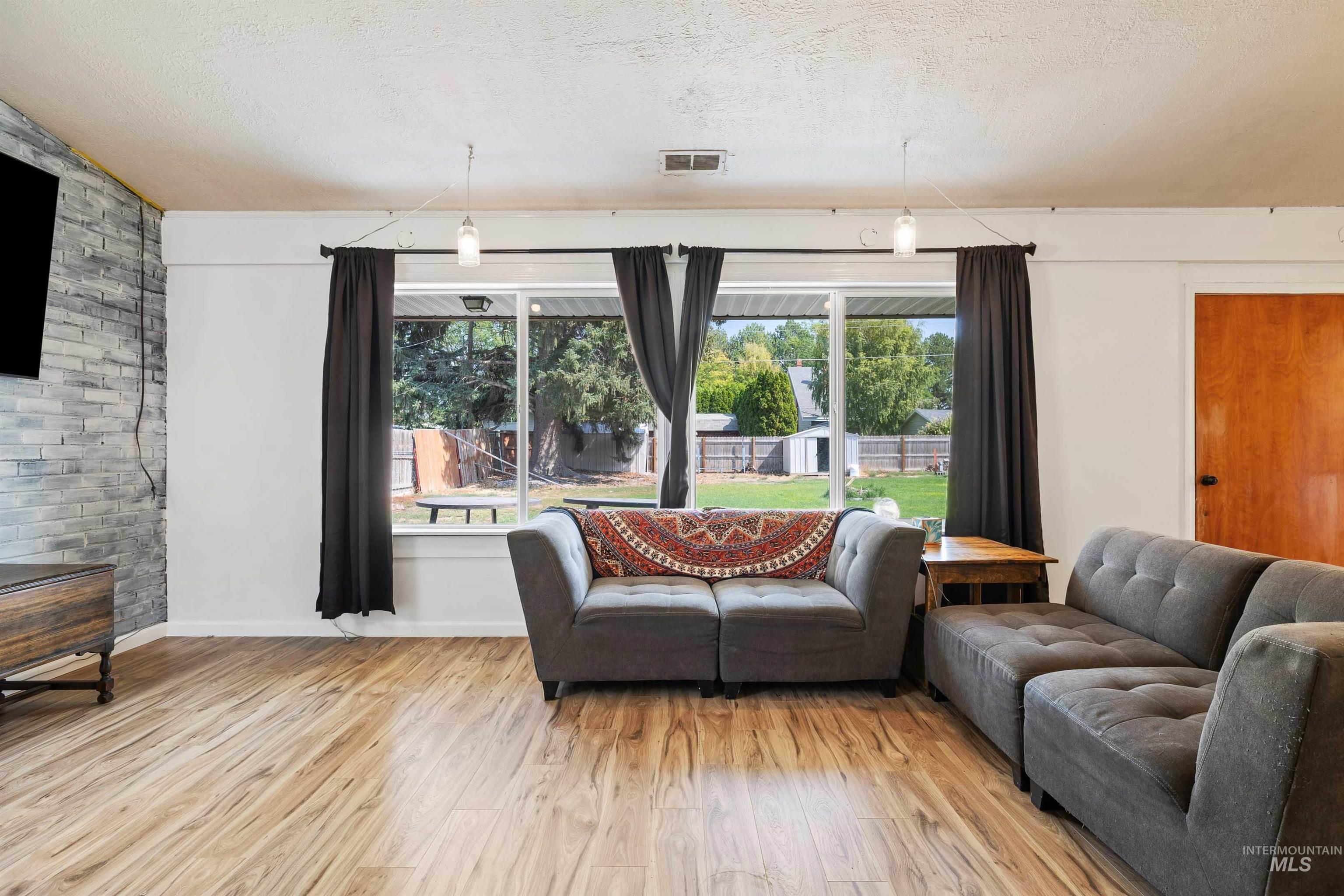 817 Union Avenue Filer, ID 83328 - Photo 5 of 37 Living room featuring wood finished floors and a textured ceiling