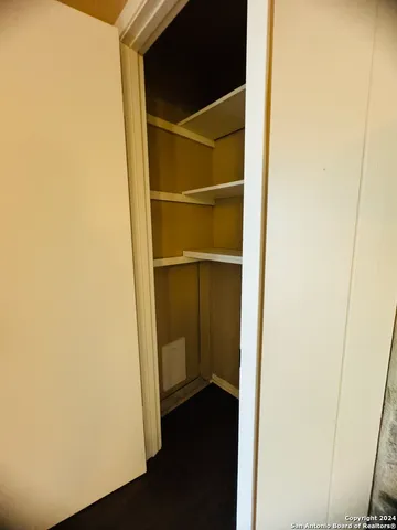 a view of a walk in closet with wooden floor