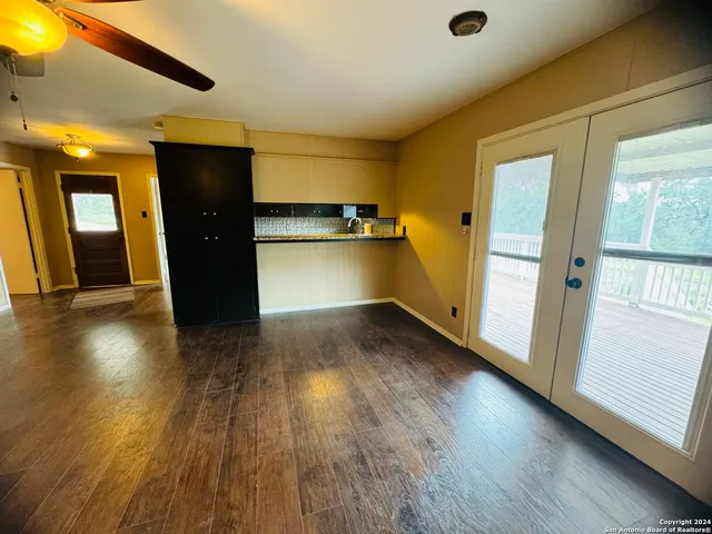 a view of a big room with wooden floor and windows