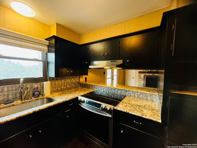 a kitchen with a sink counter top space and stainless steel appliances