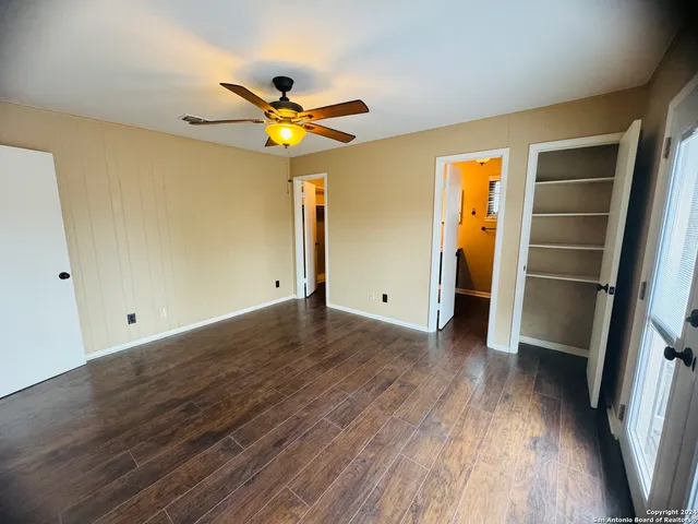 a view of empty room with wooden floor