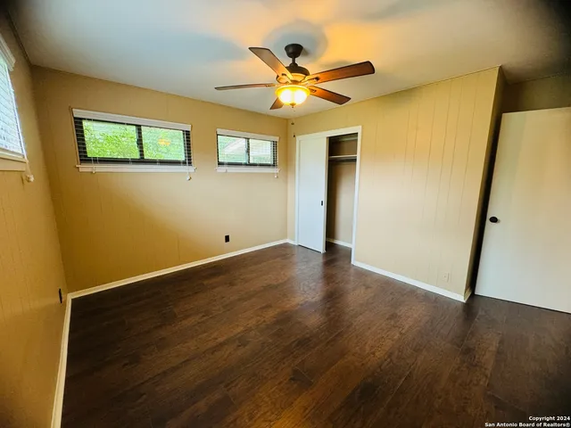 a view of a livingroom with wooden floor and a ceiling fan