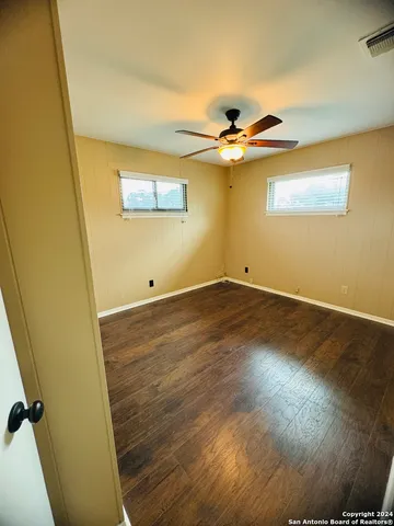 a view of room with wooden floor and fan
