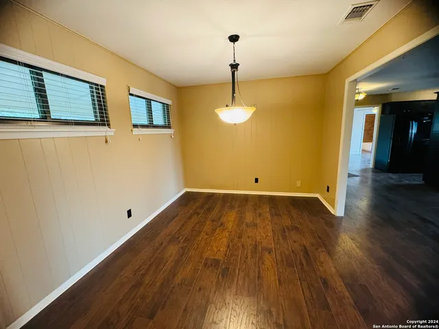 a view of a room with wooden floor and chandelier