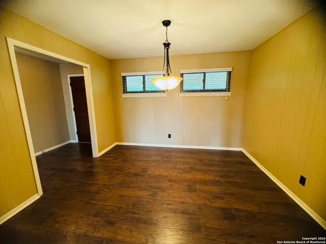 a view of a room with wooden floor and a ceiling fan