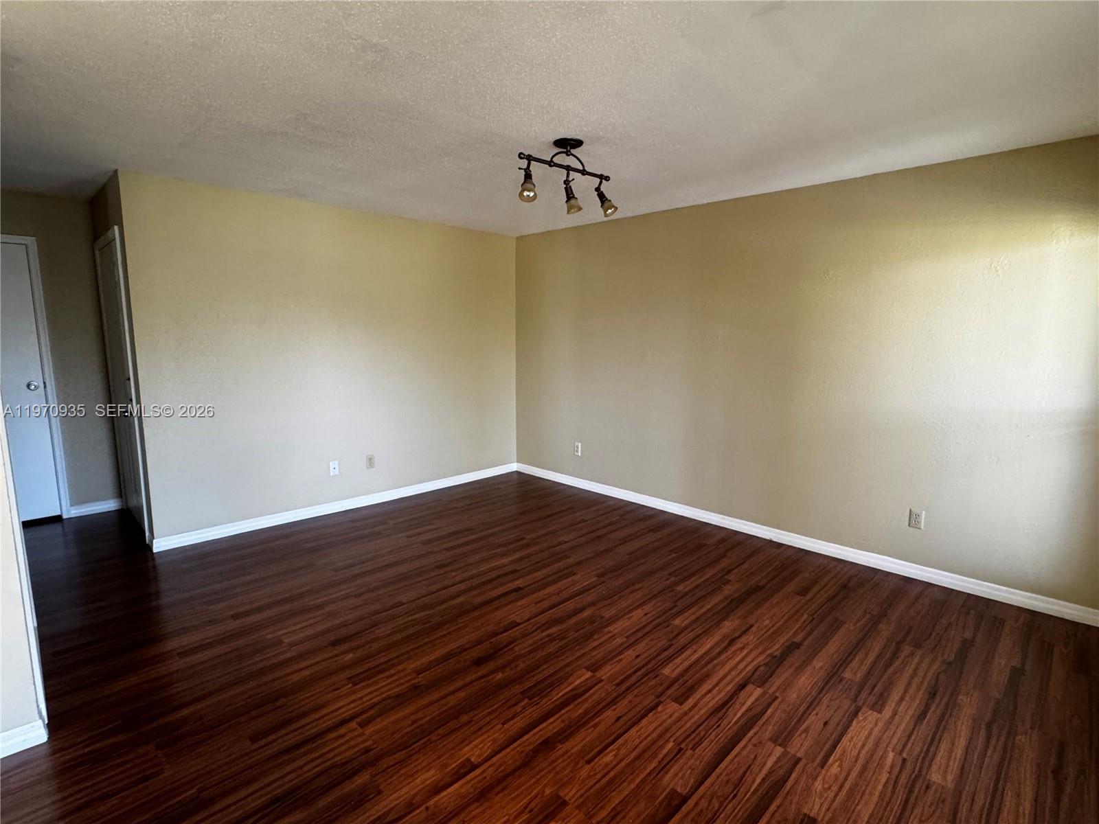977 Riverside Drive, Unit 221 Coral Springs, FL 33071 - Photo 11 of 17 a view of an empty room with wooden floor and a window