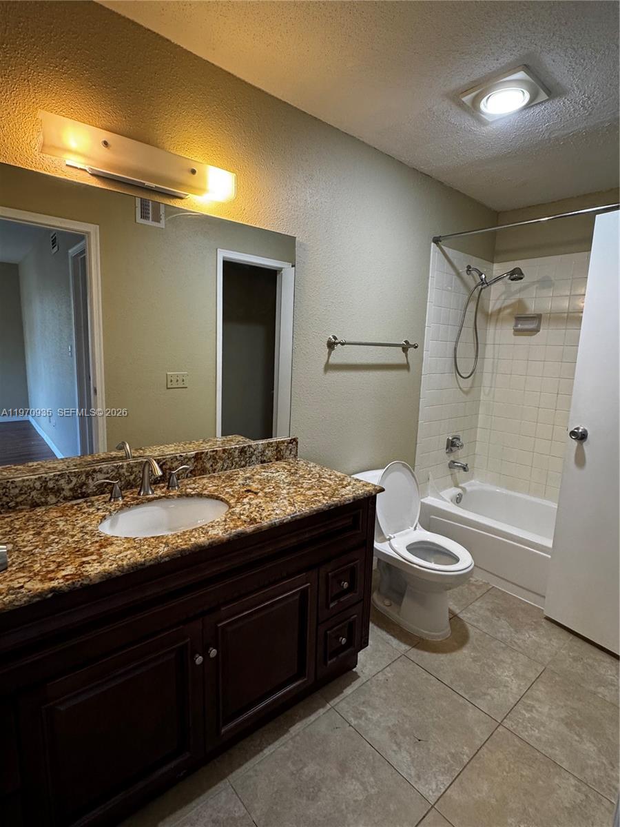 977 Riverside Drive, Unit 221 Coral Springs, FL 33071 - Photo 12 of 17 a bathroom with a granite countertop sink toilet and shower
