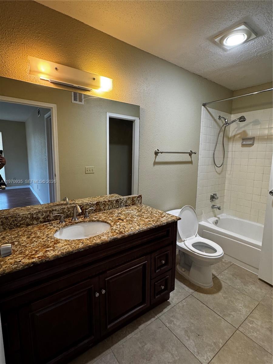 977 Riverside Drive, Unit 221 Coral Springs, FL 33071 - Photo 13 of 17 a bathroom with a granite countertop sink toilet mirror vanity and bathtub