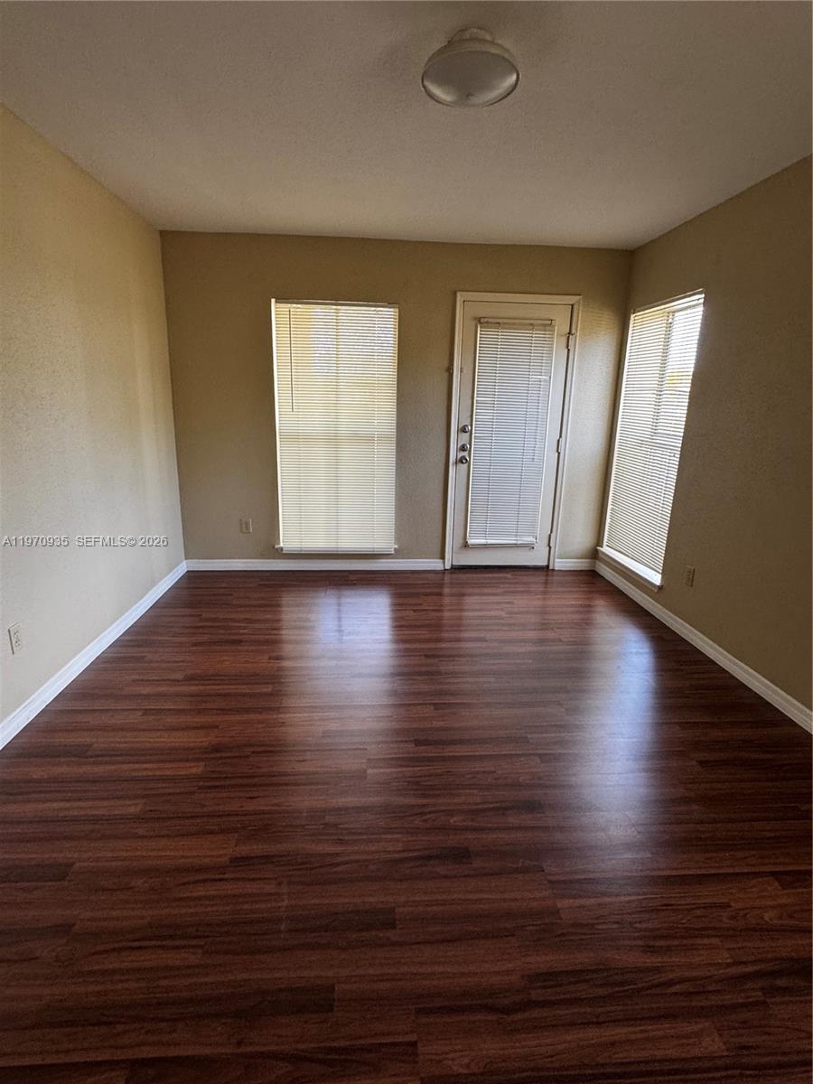 977 Riverside Drive, Unit 221 Coral Springs, FL 33071 - Photo 15 of 17 a view of an empty room with wooden floor and a window