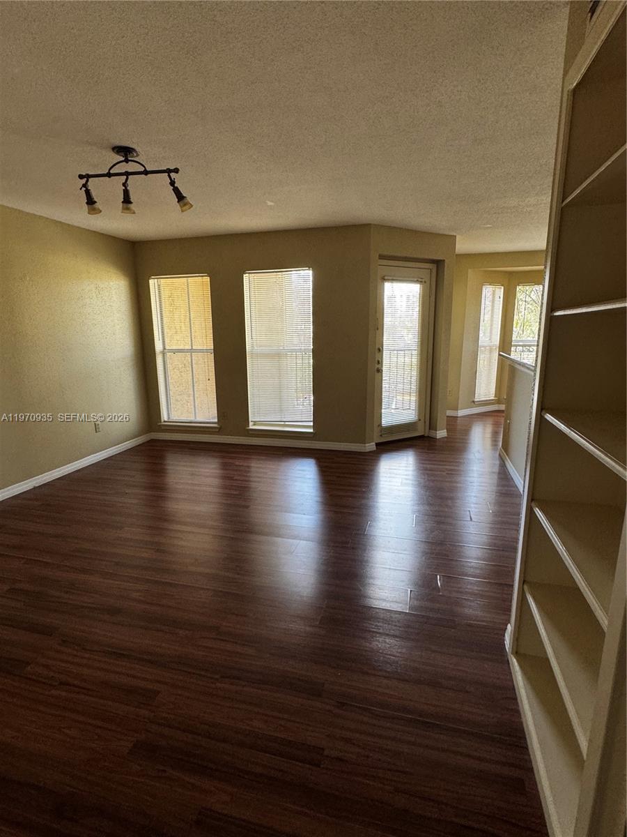 977 Riverside Drive, Unit 221 Coral Springs, FL 33071 - Photo 3 of 17 an empty room with wooden floor and windows