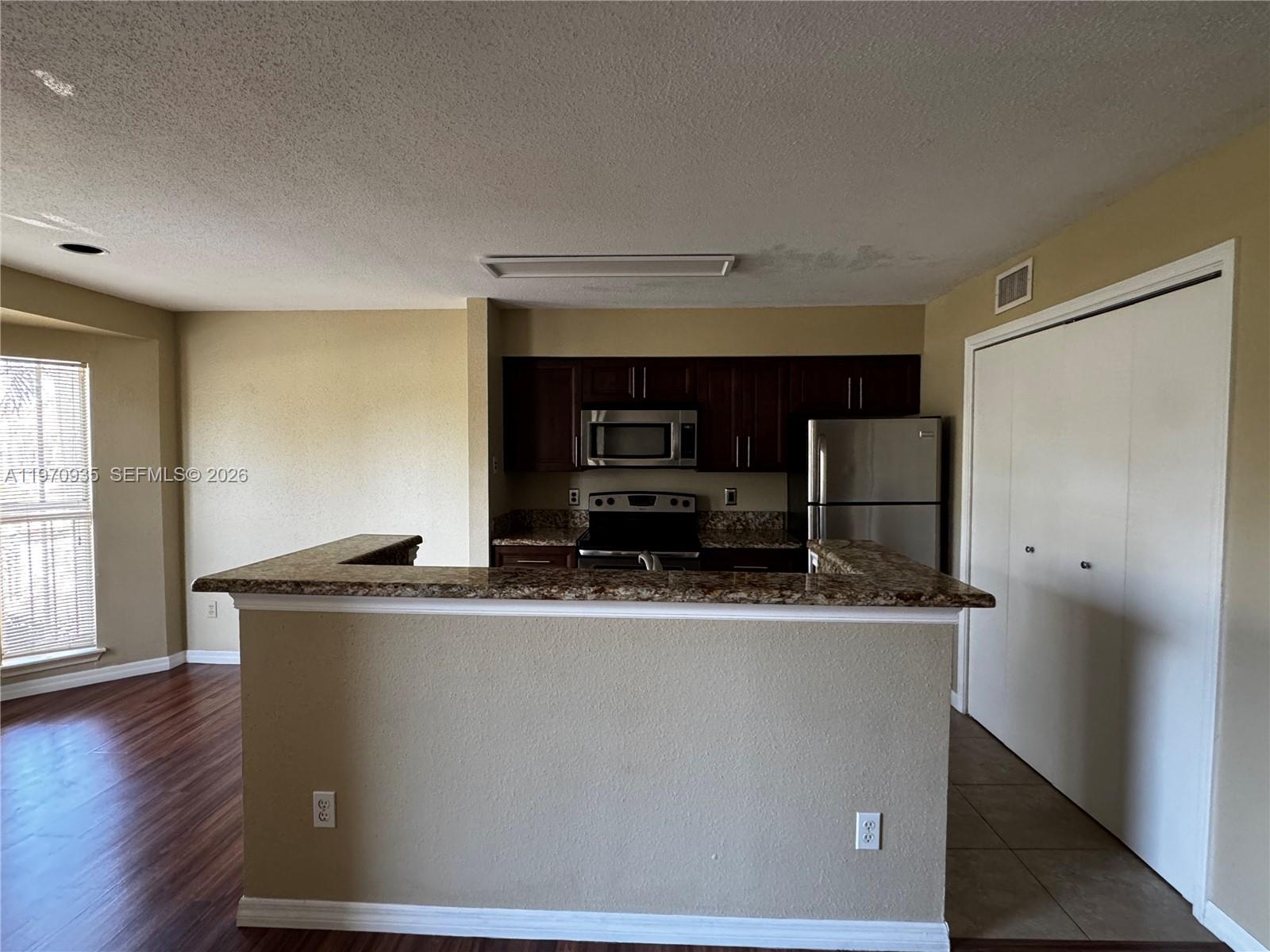 977 Riverside Drive, Unit 221 Coral Springs, FL 33071 - Photo 6 of 17 a kitchen with kitchen island a sink a stove and a refrigerator