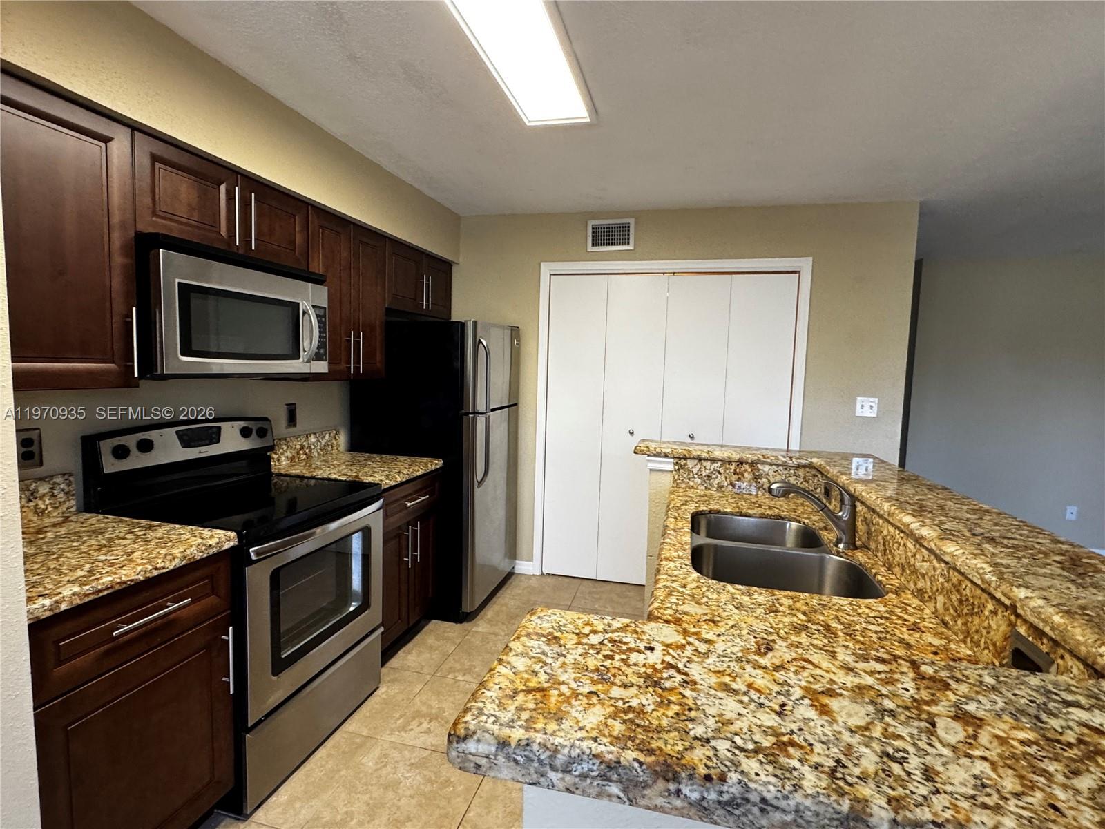 977 Riverside Drive, Unit 221 Coral Springs, FL 33071 - Photo 8 of 17 a kitchen with a stove and a microwave
