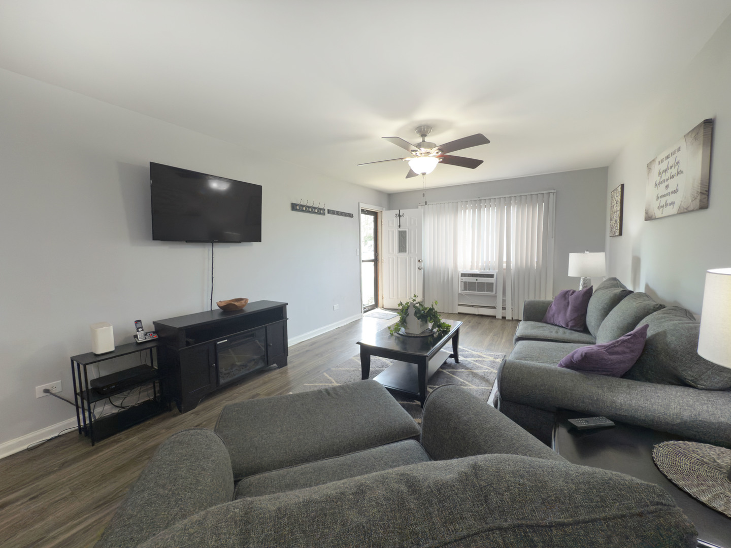 1313 Rebecca Road, Unit 118 Lombard, IL 60148 - Photo 3 of 19 a living room with couches a coffee table and a flat screen tv with wooden floor