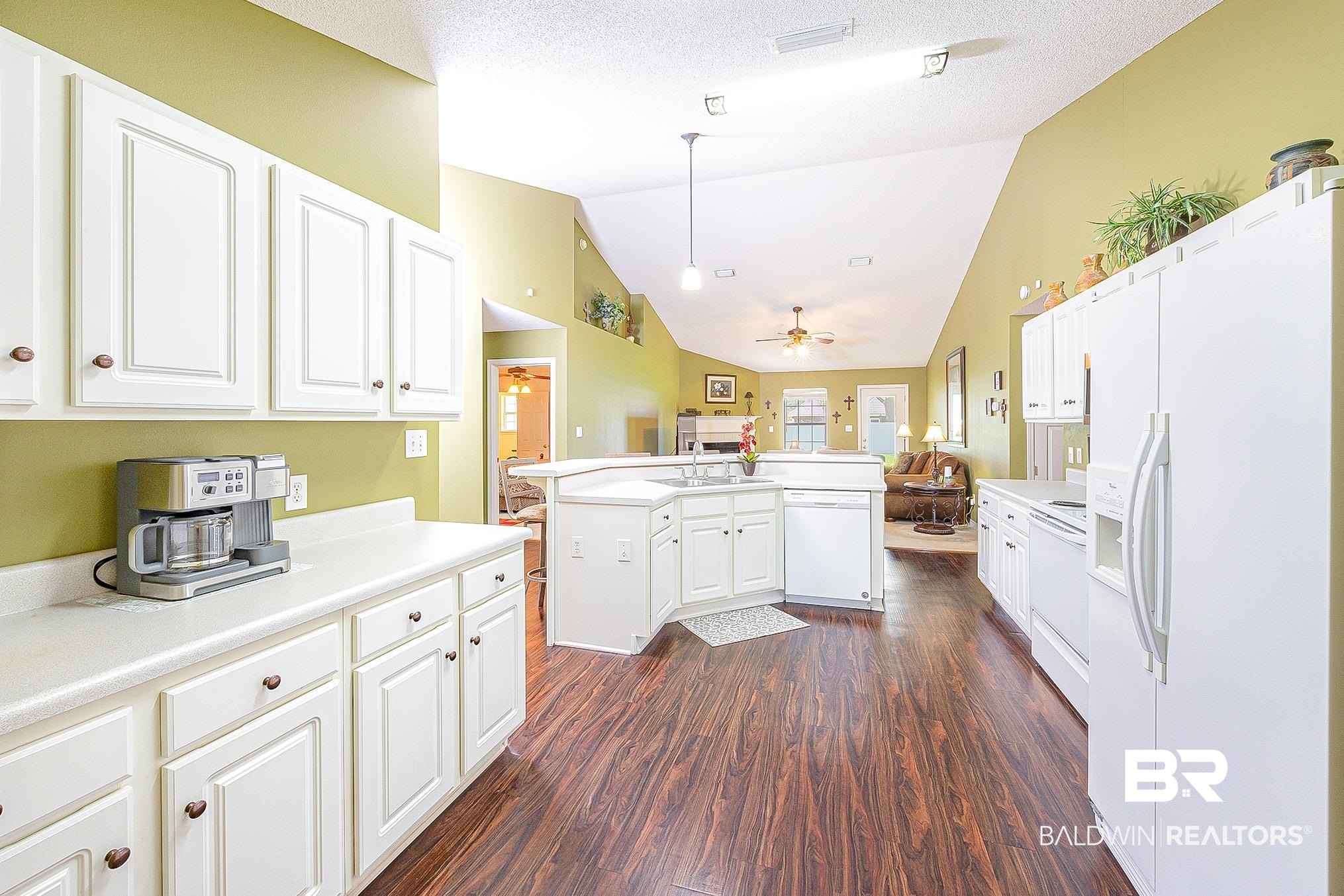 16154 Parke Boulevard Foley, AL 36535 - Photo 15 of 44 Kitchen with white appliances, vaulted ceiling, dark wood-type flooring, ceiling fan, and decorative light fixtures