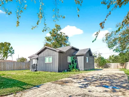 a view of a yard in front of a house with large trees
