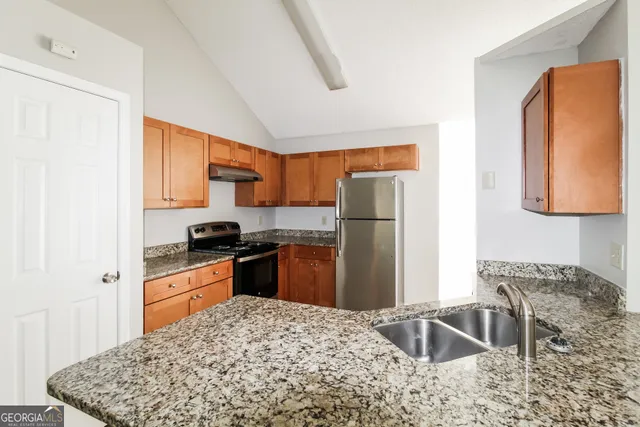 a kitchen with stainless steel appliances granite countertop a stove a sink and a microwave