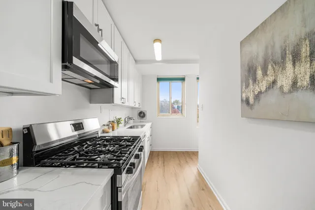 a kitchen with stainless steel appliances a stove and cabinets