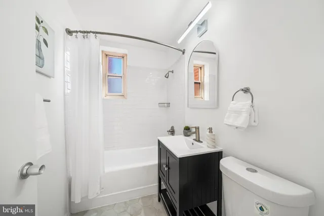 a bathroom with a toilet sink vanity and mirror