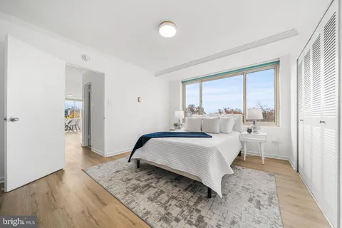 a bedroom with a bed and a large window