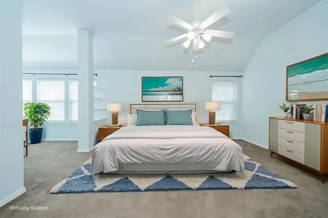 a bedroom with a large bed a chandelier and a potted plant