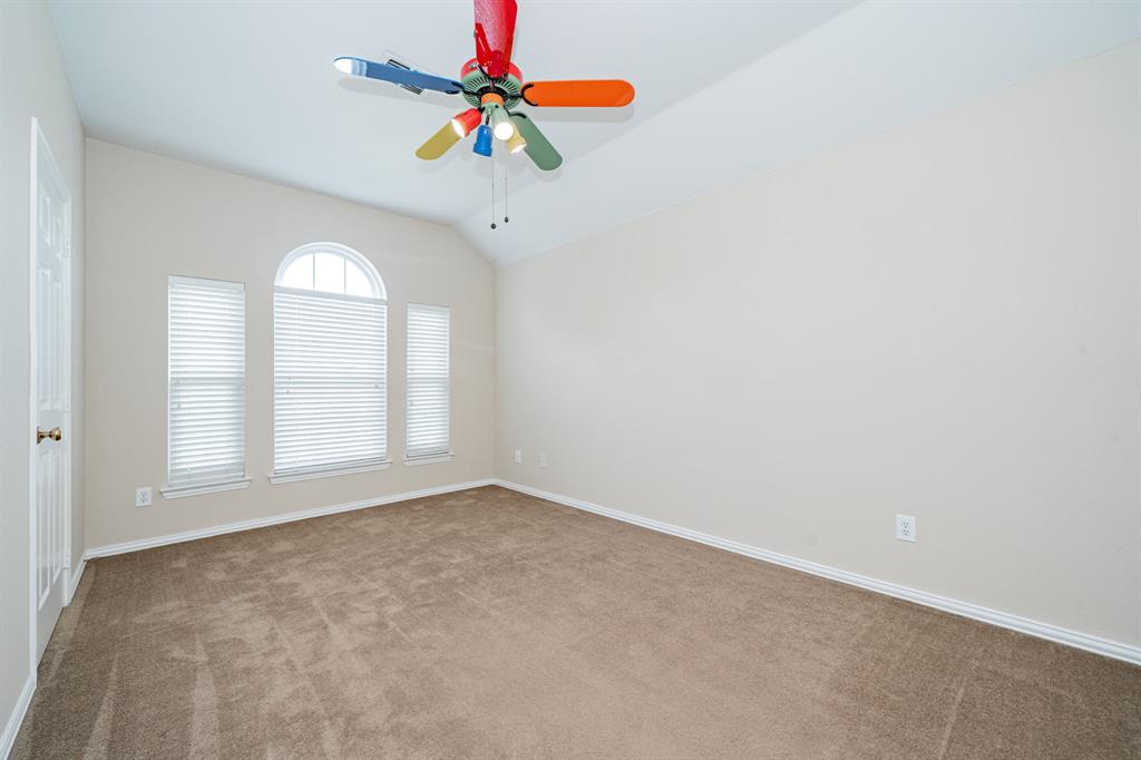 1805 Sumac Drive Flower Mound, TX 75028 - Photo 33 of 40 an empty room with a window and a chandelier fan