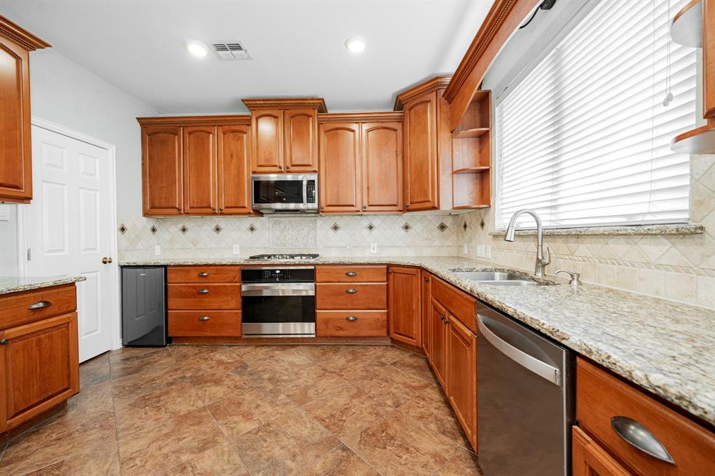 1805 Sumac Drive Flower Mound, TX 75028 - Photo 6 of 40 a kitchen with stainless steel appliances granite countertop a stove sink and cabinets