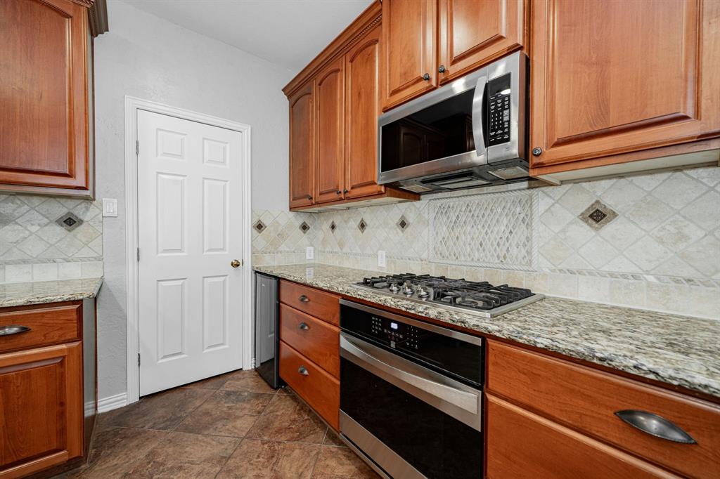 1805 Sumac Drive Flower Mound, TX 75028 - Photo 8 of 40 a kitchen with stainless steel appliances granite countertop a stove microwave and cabinets