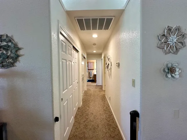 a bedroom with a large bed a flat tv screen and a dresser