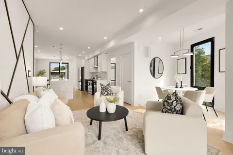 a living room with furniture kitchen view and a large window