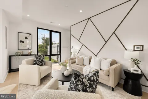 a living room with furniture kitchen view and a large window