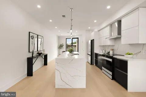 a large white kitchen with a large island oven a sink and dishwasher