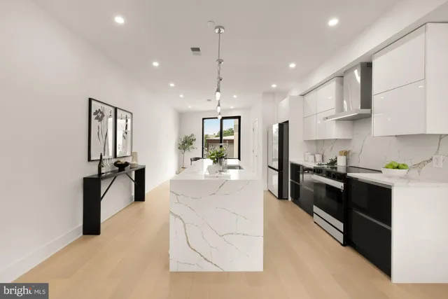 a large white kitchen with a large island oven a sink and dishwasher