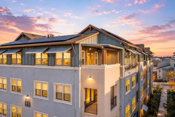 a front view of a residential apartment building with a yard