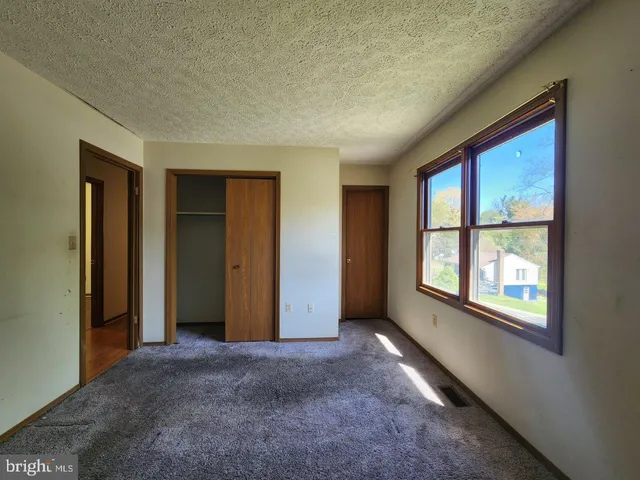 an empty room with windows and closet