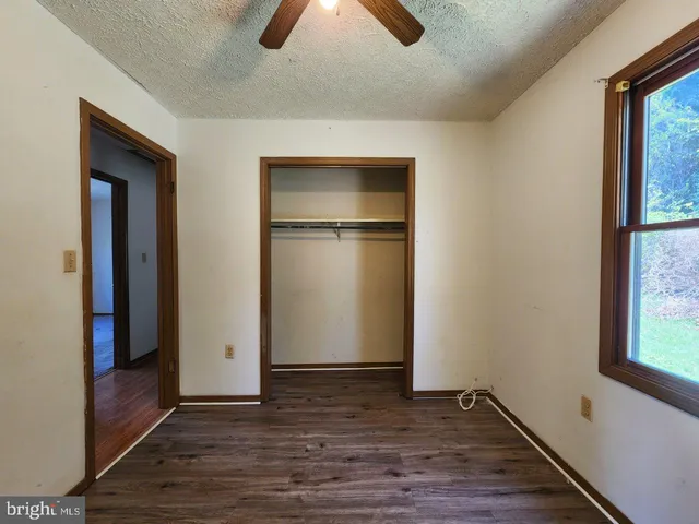 an empty room with closet and windows