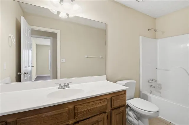 a bathroom with a granite countertop toilet sink and mirror