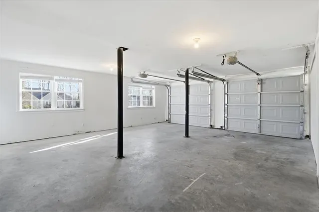 an empty room with windows and ceiling fan