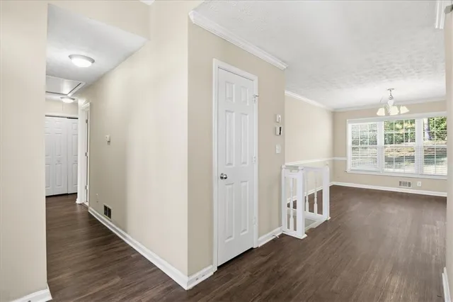 a view of a hallway with wooden floor and a living room
