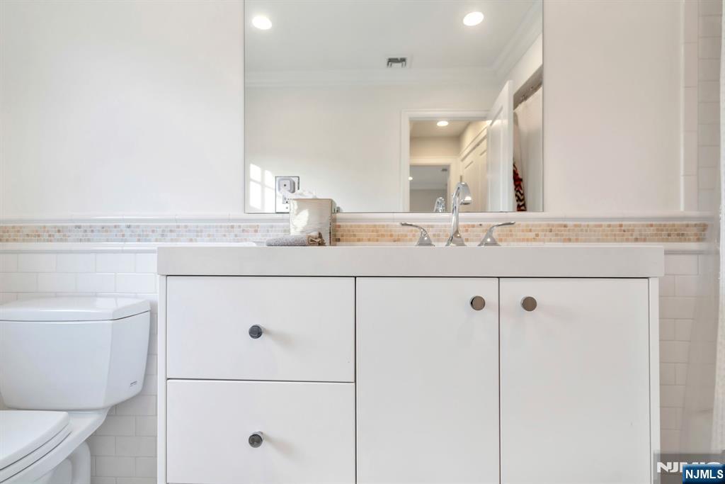 187 Buckingham Road Tenafly, NJ 07670 - Photo 33 of 50 a bathroom with a granite countertop sink mirror vanity and toilet