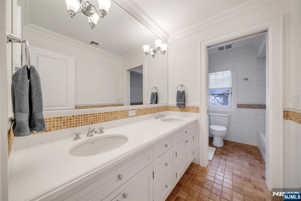 187 Buckingham Road Tenafly, NJ 07670 - Photo 35 of 50 a bathroom with a double vanity sink and a mirror