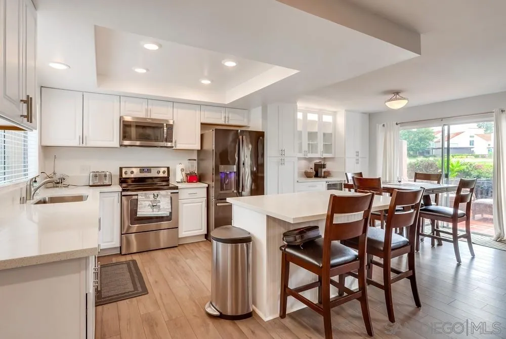 23667 Country Villa Road Ramona, CA 92065 - Photo 3 of 25 a kitchen with microwave a refrigerator and chairs
