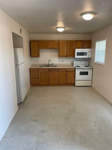a kitchen with stainless steel appliances a stove a sink and a refrigerator