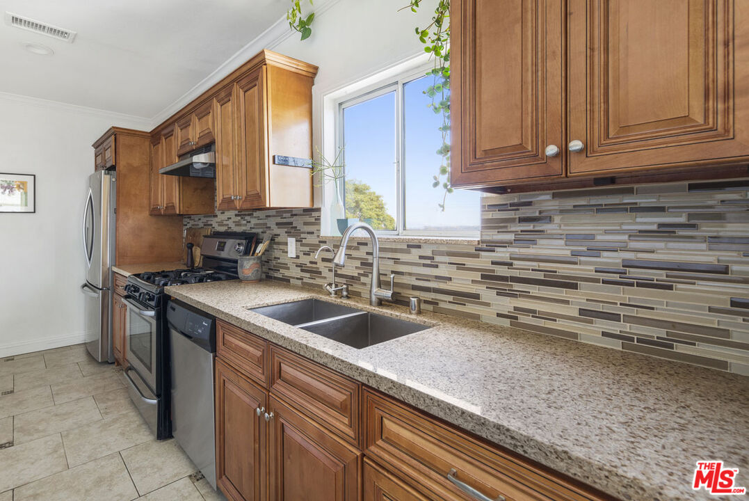 3922 Edison Walk Los Angeles, CA 90032 - Photo 7 of 26 a kitchen with stainless steel appliances granite countertop a sink stove and refrigerator