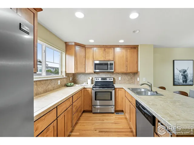 a kitchen with stainless steel appliances granite countertop a sink stove cabinets and refrigerator