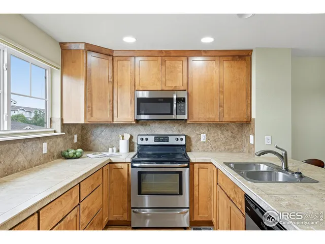 a kitchen with stainless steel appliances a stove sink microwave and cabinets