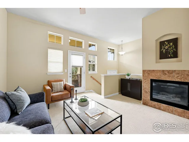 a living room with furniture a fireplace and a large window