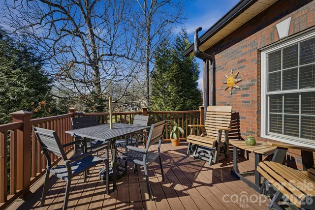 a view of a roof deck with table and chairs with wooden floor and fence