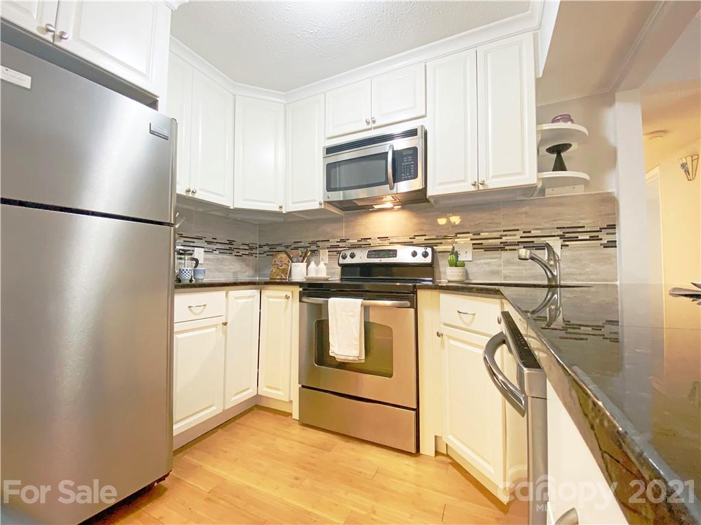 2606 Park Road Charlotte, NC 28209 - Photo 7 of 16 a kitchen with stainless steel appliances granite countertop a refrigerator a stove a sink and white cabinets